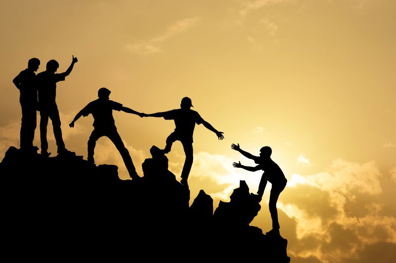 Person helping another person up an incline