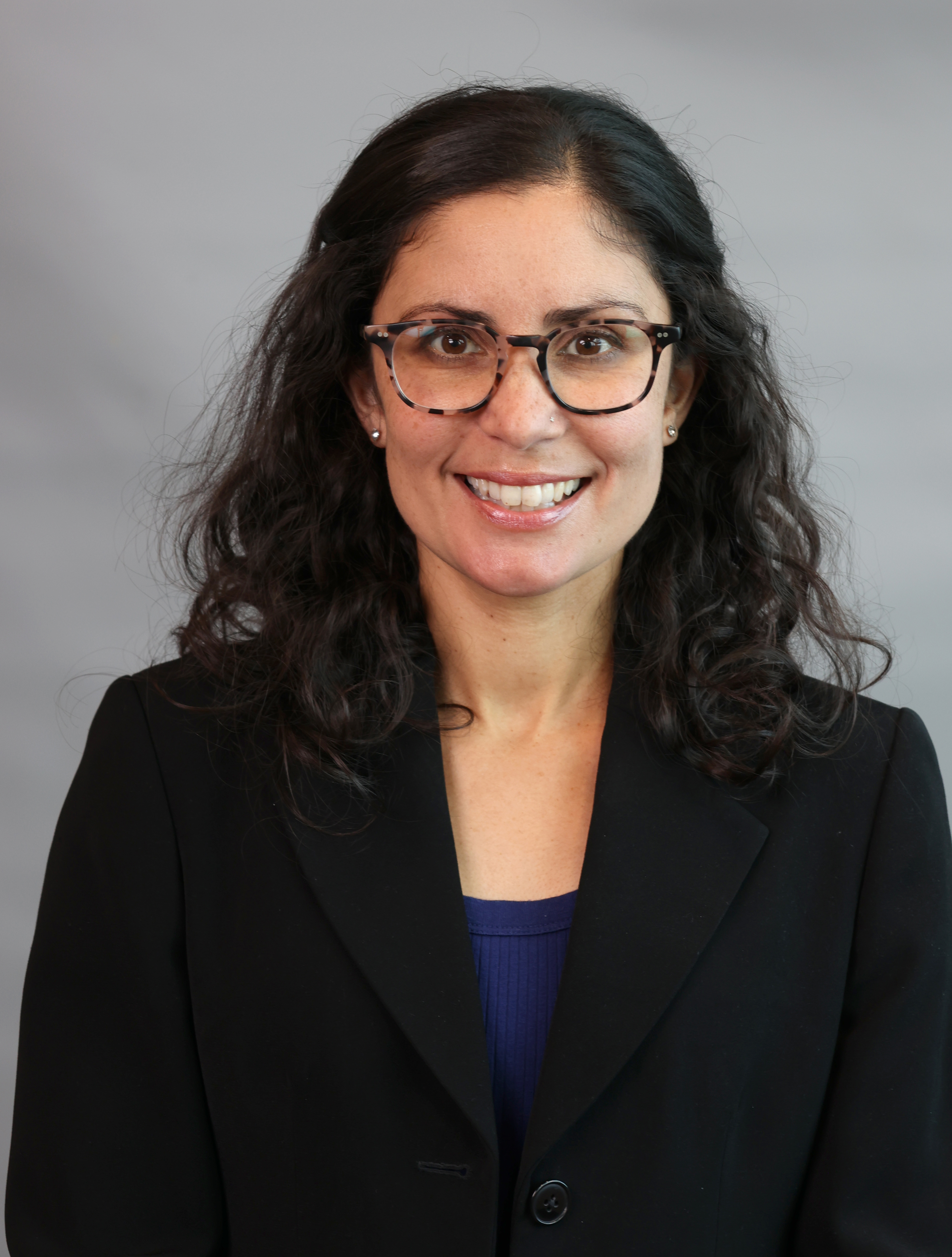 yasmin in a dark suit smiling at camera