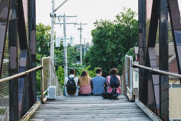 A group of young people walking over a bridge