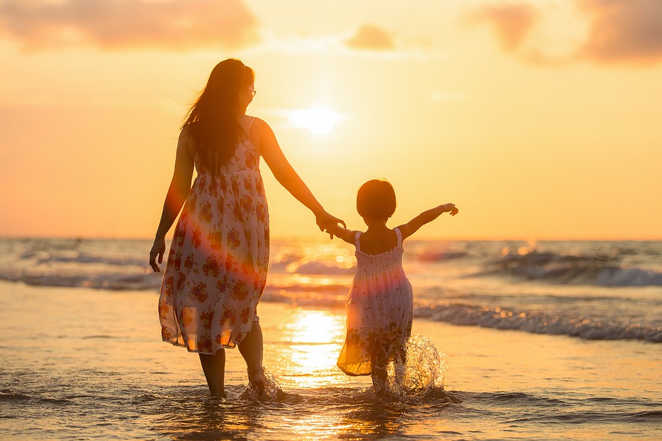 mother and child on the beach at sunset