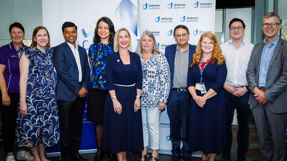 Image of people standing in front of ACADI and Diabetes Australia banners for the launch of ADCTN