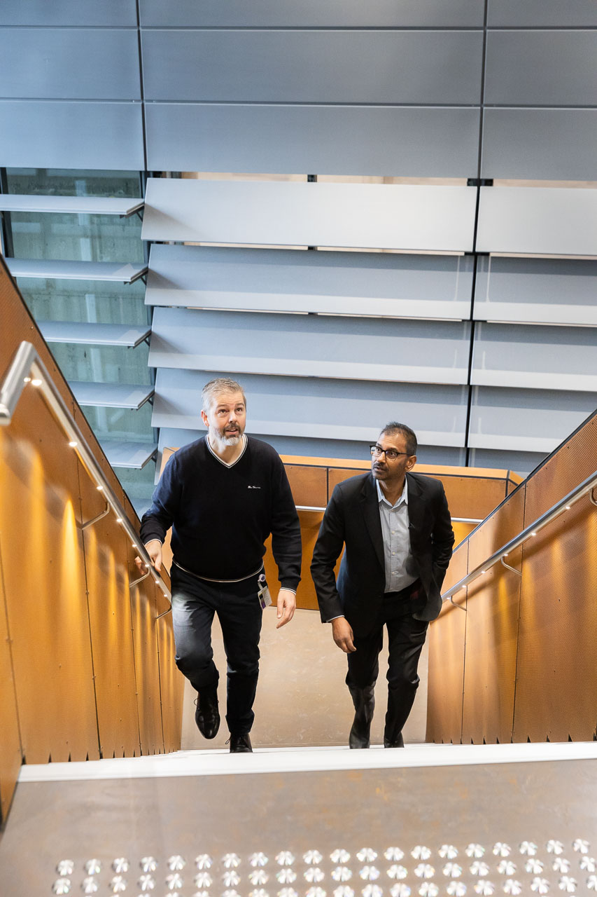 L-R Media and Communications Manager Christopher Best and Professor Sarath Ranganathan climb the stairs of the Atrium at ACMD