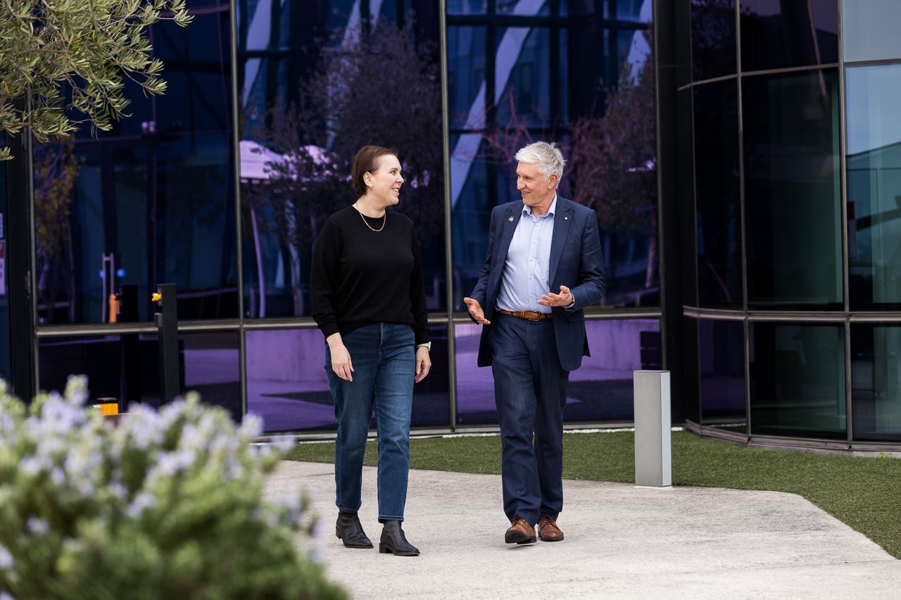 Professor Grant McArthur AO and Melissa Sheldon walking together in the rooftop garden at the VCCC.