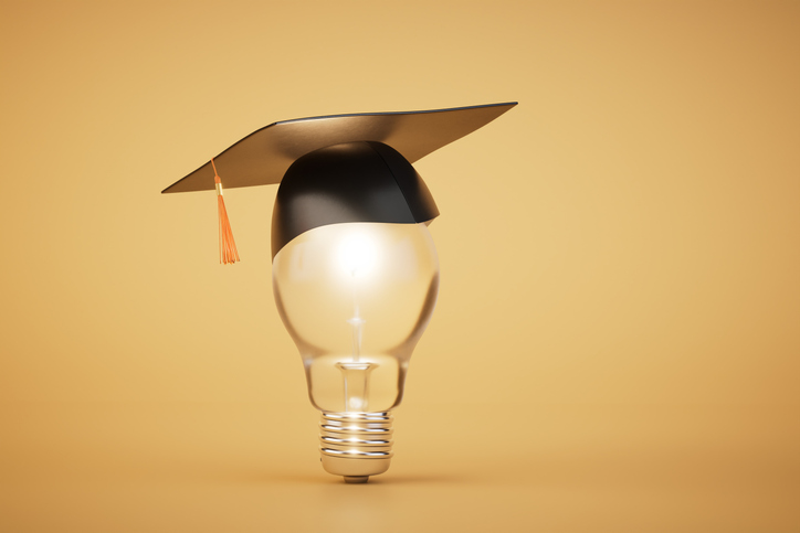 A lightbulb with a mortarboard/graduation cap, with a simple clear background.